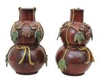 Par de vasos na forma de bulbos, em cerâmica chinesana cor sang de boeuf, apresentando decoração emrelevo com folhagens e insetos em policromia.Séc. XIX. Alt. 51 cm