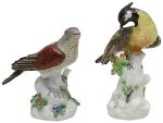 Conjunto de duas estatuetas modeladas em figuras de pássaros, apoiados em rochedo florido, em porcelana alemã de Meissen, decorados em bela policromia naturalística. Marcas da manufatura na base. Séc. XIX. Alt. 24,5 e 20 cm