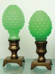 Conjunto de duas pinhas em vidro leitoso verde lapidadas em cabochons com base em bronze. Alts. 20 e 21 cm