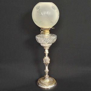 <b>Lampião</b> provavelmente francês em metal espessurado a prata com recipiente em vidro prensado e cúpula globular. Algumas inscrições na parte superior. Alt. 70 cm