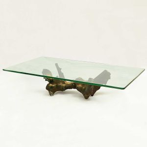 <b>AGOSTINELLI, MARIO </b><br>(1915-2000)<br>Base para mesa de centro, em bronze,  insinuando uma figura.<br>Tampo em vidro (med. 160 x 89 cm) <br>21 x 82 x 45 cm