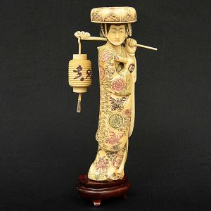 Requintada <b>estatueta</b> chinesa em marfim representando figura feminina com elaboradas vestes policromadas. Lanterna e leque às mãos. Alt. 23,5 cm