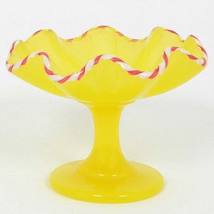<b>Pequena salva de pé</b> em uralina francesa amarela, com borda ondulatória e friso torcido em vermelho e branco. Séc. XIX. Alt. 8 cm; Diâm. 9 cm
