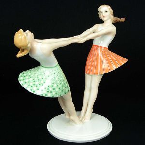 <b>Estatueta</b> "Art Déco" em porcelana alemã Rosenthal representando duas jovens em rodopio com saias policromadas. Marca da manufatura no verso. Alt. 21,5 cm; Compr. 23,5 cm