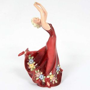 <b>Estatueta</b> em cerâmica policromada europeia, representando dançarina com longas vestes de barra movimentada decorada com flores. Apresenta restauro. Alt. 30,5 cm