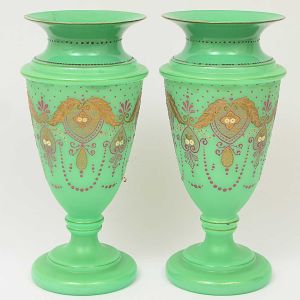 <b>Par de vasos</b> franceses em opalina verde apresentando decoração em esmalte grená formando guirlandas. Séc. XIX. Um deles com restauro na borda. Alt 38 cm