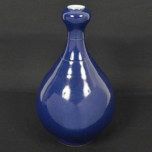 <b>Vaso</b> chinês bojudo em porcelana com gargalo estreitado e coberto por esmalte azul índigo. Marcas no verso. Alt. 41 cm