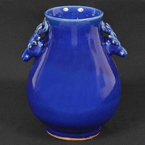 <b>Vaso</b> chinês piriforme, em porcelana, coberto por esmalte azul índigo, apresentando pegas no feitio de alces. Alt. 28,5 cm