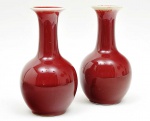 <b>Par de vasos</b> bojudos de gargalo alongado em porcelana chinesa cobertos por esmalte monocromático "sang de boeuf". Marcas no verso. Alt. 20 cm