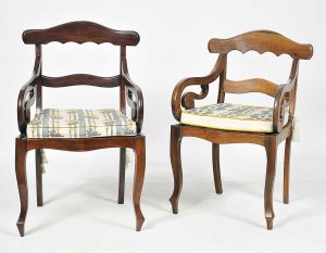 Conjunto de <b>2 cadeiras de braços</b>, muito similares, brasileiras império em jacarandá, sendo uma de tonalidade ligeiramente mais clara. Estrutura movimentada, pés de cachimbo e assento em palhinha. Acompanham almofadas em tecido. Alt. 93 cm